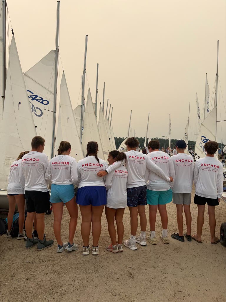 AYC race-team sailors wearing Anchor Real Estate sponsor shirts at a regatta